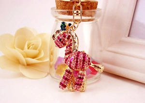 Primo piano di un portachiavi a giraffa con strass rosa e finitura dorata lucida