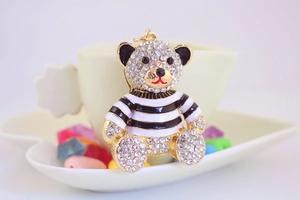 Dettaglio portachiavi a forma di orsetto con strass e maglione a righe bianche e nere
