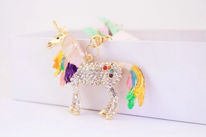 Close-up of golden unicorn keychain featuring vibrant enamel mane and sparkling crystals