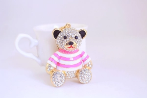 Dettaglio di un simpatico portachiavi a forma di orso con strass e smalto rosa a righe