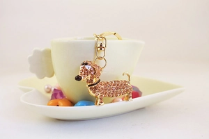 Détail d'un porte-clés teckel mignon avec strass accroché sur une tasse en céramique