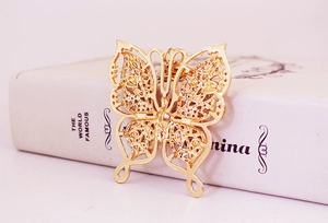 Detailed view of golden butterfly keychain with hollow filigree and engraved wing textures