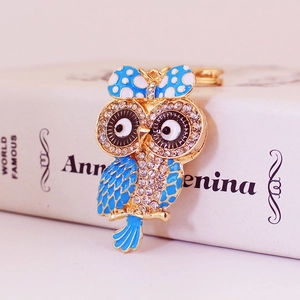 Joli porte-clés hibou doré avec des ailes en émail bleu et des cristaux brillants
