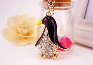 Close-up of cute penguin keychain with sparkling white rhinestones and black enamel finish