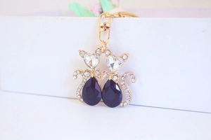 Detail of fox-themed gold keychain with black heart-shaped gems and tiny crystal accents