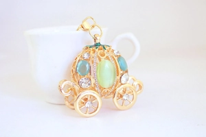 Detailed macro view of the golden pumpkin carriage keychain with vibrant gemstones