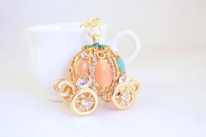 Detail of golden pumpkin carriage keychain with pink opal and sparkling rhinestones