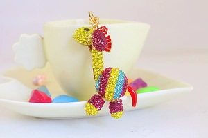 Dettaglio del portachiavi a forma di giraffa con strass colorati e finiture in oro lucido