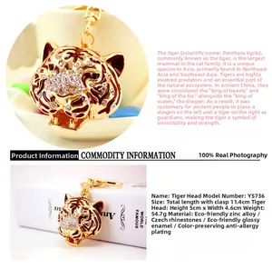 Vue détaillée du porte-clés tête de tigre doré avec strass et émail rouge brillant