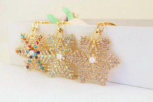 Vue détaillée de trois porte-clés flocon de neige avec strass et perles blanches