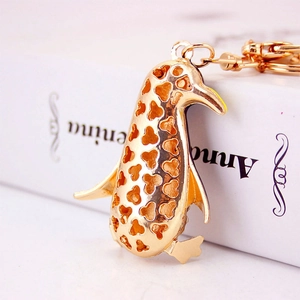 Creative golden penguin keychain with hollow heart patterns and premium metal finish