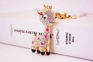 Detail of a gold giraffe keychain with sparkling rhinestones and pink polka dots