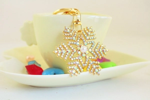 Détail d'un porte-clés flocon de neige avec strass arc-en-ciel et perle sur une tasse