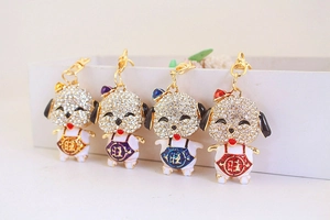 Detail of four colorful rhinestone puppy keychains with gold plating and enamel finish