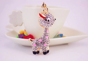 Close-up of golden giraffe keychain with sparkling rhinestones and pink enamel spots