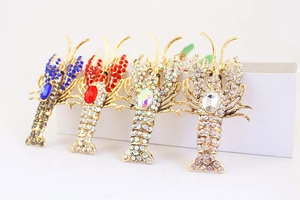 Detailed macro view of lobster-shaped keychains with crystal rhinestones in four colors