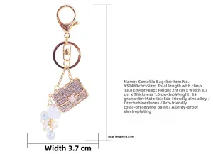 Vue détaillée du porte-clés sac à main strass avec camélia, perles et dimensions exactes