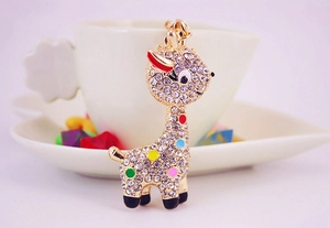 Detail of a gold giraffe keychain featuring colorful enamel spots and sparkling crystals