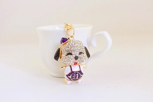 Close-up of golden dog keychain featuring sparkling rhinestones and red enamel Wang design