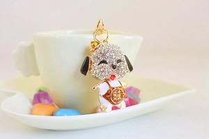 Close-up of golden dog keychain with rhinestones and Fu character on a white cup