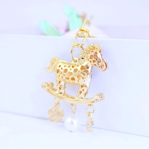 Porte-clés cheval de manège doré avec design évidé en cristal et pendentif perle