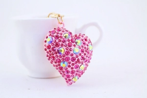 Vista macro del portachiavi a cuore con strass rosa e gancio dorato per borsa da donna