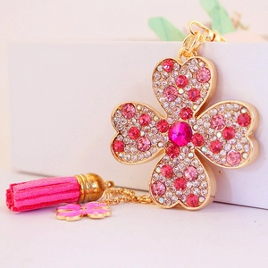 Porte-clés trèfle en strass rose avec pompon doré et breloque fleur émaillée