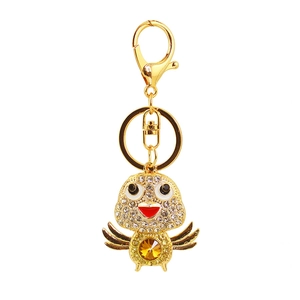 Detailed macro view of a gold-tone crystal bird keychain with sparkling orange gemstones