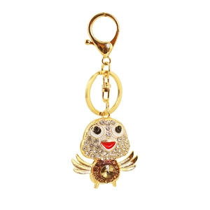 Close-up of golden bird keychain featuring amber crystal and sparkling rhinestones
