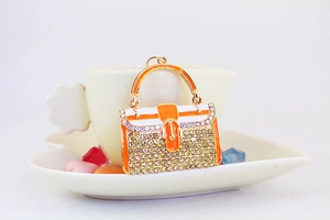 Detailansicht der orangefarbenen Handtasche Schlüsselanhänger mit Strass und Goldfinish