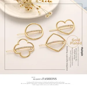 Close-up of gold-plated hair clips featuring geometric shapes and crystal rhinestones