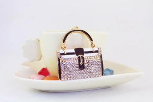 Makroaufnahme des Taschen-Schlüsselanhängers mit glitzernden Strasssteinen und Emaille