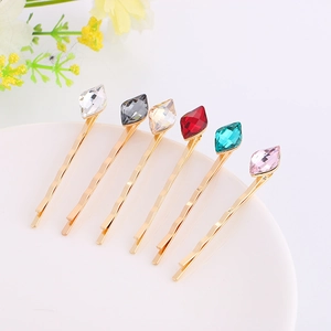 Detailed macro view of six gold wave hair clips with multi-colored diamond crystal studs