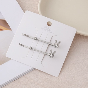 Close-up of rabbit hair clips with shiny rhinestones and silver finish on display card