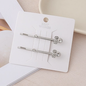 Detail view of silver alloy hair clips with sparkling crystals on a display card