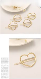 Detail of four gold geometric hair clips with hammer texture and white rhinestones