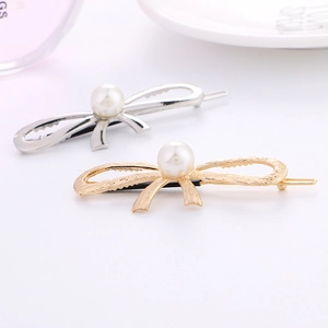 Elegant gold and silver bow hair clips with pearls shown in a decorative lifestyle setting
