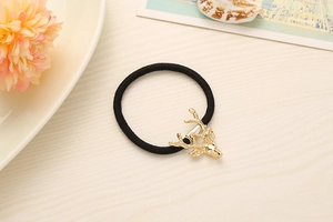 Detail of high-elasticity hair tie with a gold metal elk head charm on wood surface