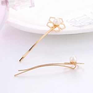 Détail de l'ensemble de barrettes dorées géométriques avec perles sur fond blanc