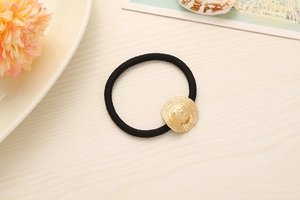 Close-up of high-elastic black hair tie with detailed golden straw hat metal pendant