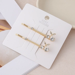 Golden cherry-shaped crystal hair clips with sparkling stones on elegant white card