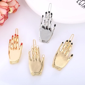 Set dettagliato di quattro fermagli per capelli a mano di scheletro in oro e argento con smalto