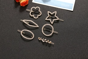 Detail view of a six-piece gold-plated rhinestone hair clip set with various geometric shapes