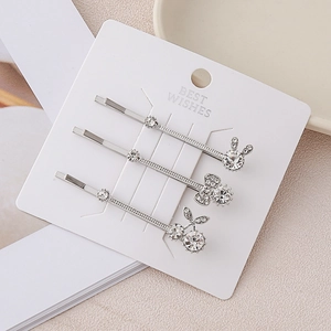 Three-piece silver crystal hair clip set with rabbit bow and cherry designs on card