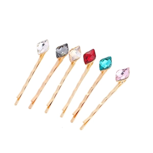 Set of six gold bobby pins with colorful rhombus crystal accents in a neat diagonal layout