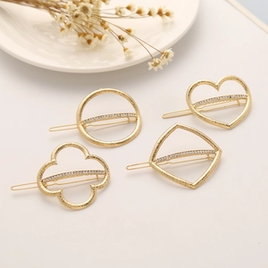 Set of four gold matte metal hair clips with rhinestones in geometric and heart shapes