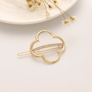 Barrette trèfle dorée ornée de strass avec une texture martelée élégante