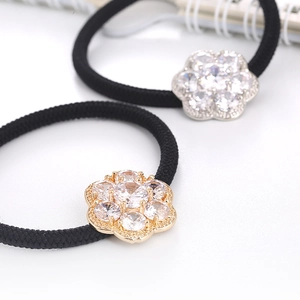 Detailed macro view of black elastic hair ties featuring luxury cubic zirconia flower charms