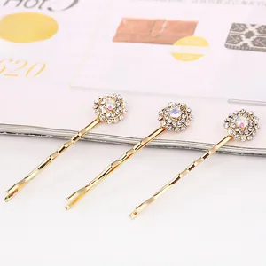 Détail de barrettes dorées en tournesol avec strass aurore et cristaux blancs brillants