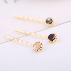 Three minimalist gold plated hair clips with acetate circle marble patterns